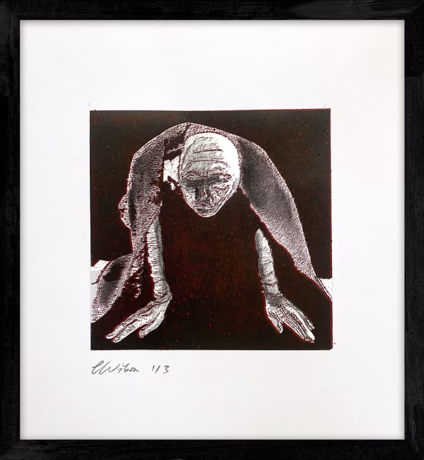 A woman crawls along the ground. She is bald, skeletal and covered in a removal blanket. Printed and tinted/shaded in black and red.