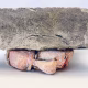 Soft sculpture head crushed by a brick