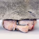 Soft sculpture head crushed by a brick