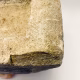 Soft sculpture head crushed by a brick