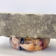 Soft sculpture head crushed by a brick