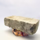 Soft sculpture head crushed by a brick