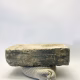 Soft sculpture head crushed by a brick