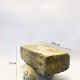 Soft sculpture head crushed by a brick
