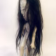 Uncanny girl doll with long dark brown hair.