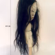Uncanny girl doll with long dark brown hair.