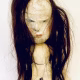 Uncanny girl doll with long dark brown hair.