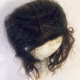 Uncanny girl doll with long dark brown hair. View from above.