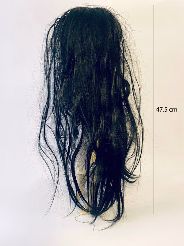 Uncanny girl doll with long dark brown hair. Back view.