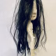 Uncanny girl doll with long dark brown hair.