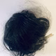 Uncanny girl doll with long dark brown hair. Seen from above.
