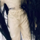 Uncanny girl doll with long dark brown hair. Hip view.