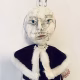 Hacked doll with a Kilner jar clip around its 'ugly' uncanny head.