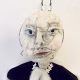 Hacked doll with a Kilner jar clip around its 'ugly' uncanny head.