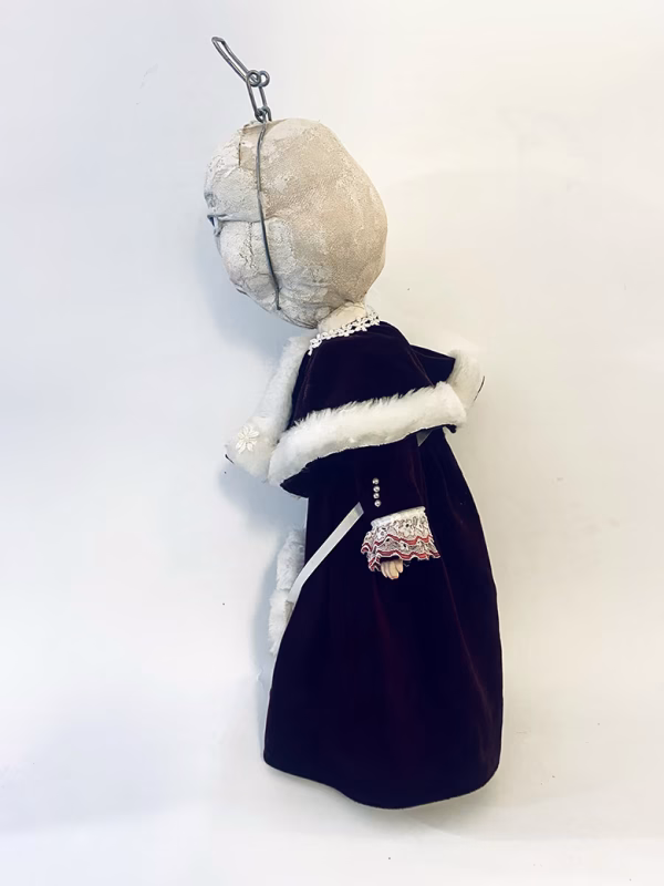 Hacked doll with a Kilner jar clip around its 'ugly' uncanny head.