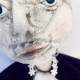 Hacked doll with a Kilner jar clip around its 'ugly' uncanny head.