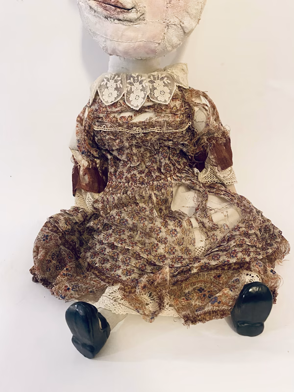 Hacked doll with decayed silk dress. The original ‘pretty’ head is replaced with an oversized, bald, uncanny head.