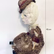 Hacked doll with decayed silk dress. The original ‘pretty’ head is replaced with an oversized, bald, uncanny head.