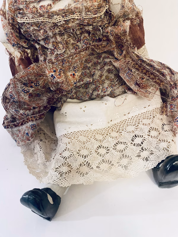 Doll with decayed silk dress.
