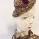 Hacked doll with decayed silk dress. The original ‘pretty’ head is replaced with an oversized, bald, uncanny head.
