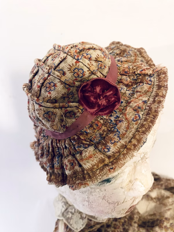 Hacked doll with decayed silk dress. The original ‘pretty’ head is replaced with an oversized, bald, uncanny head.
