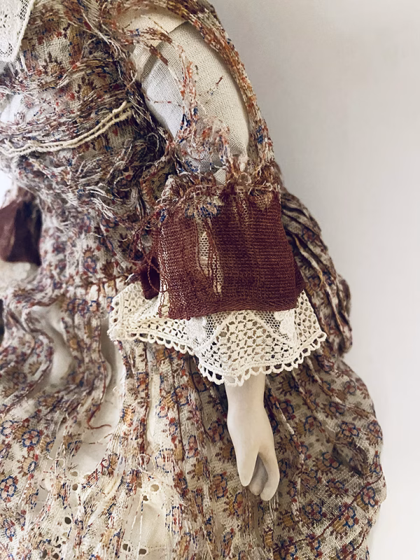 Doll with decayed silk dress.