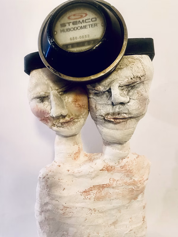 Double headed skeletal torso sculpture crowned with a vintage mechanical hubodometer