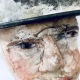 Close-up of head sculpture resting on a household iron trivet with a head piece of three stacked laboratory sieves.