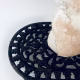 Base of head sculpture resting on a household iron trivet with a head piece of three stacked laboratory sieves.