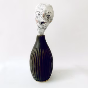 Small sculpture head emerging from ceramic pot