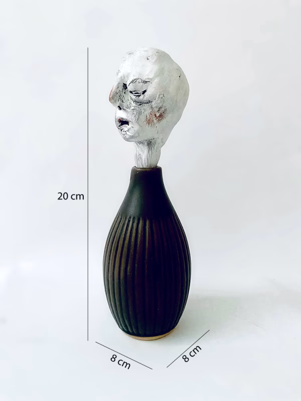 Small sculpture head emerging from ceramic pot