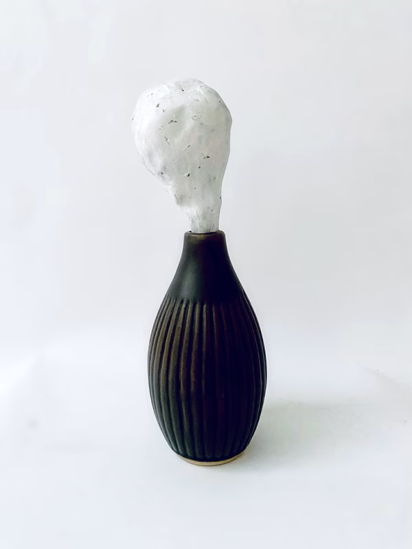 Small sculpture head emerging from ceramic pot