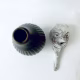 Small sculpture head next to ceramic pot