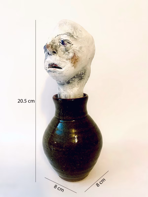 Small sculpture head emerging from ceramic pot