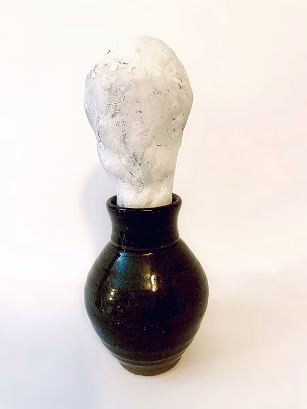 Small sculpture head emerging from ceramic pot