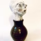 Small sculpture head emerging from ceramic pot