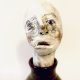 Small sculpture head emerging from ceramic pot