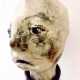Small sculpture head emerging from ceramic pot