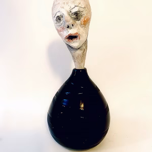 Small sculpture head emerging from ceramic pot
