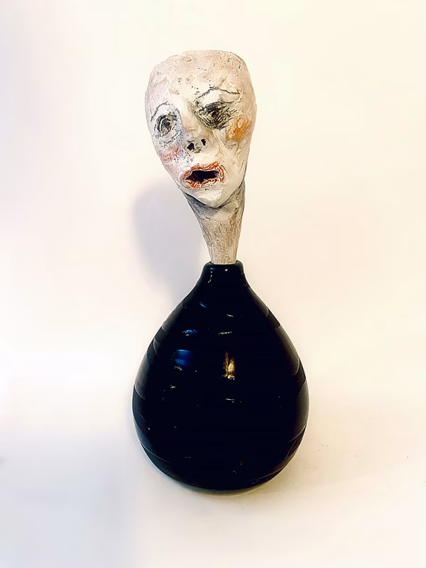 Small sculpture head emerging from ceramic pot