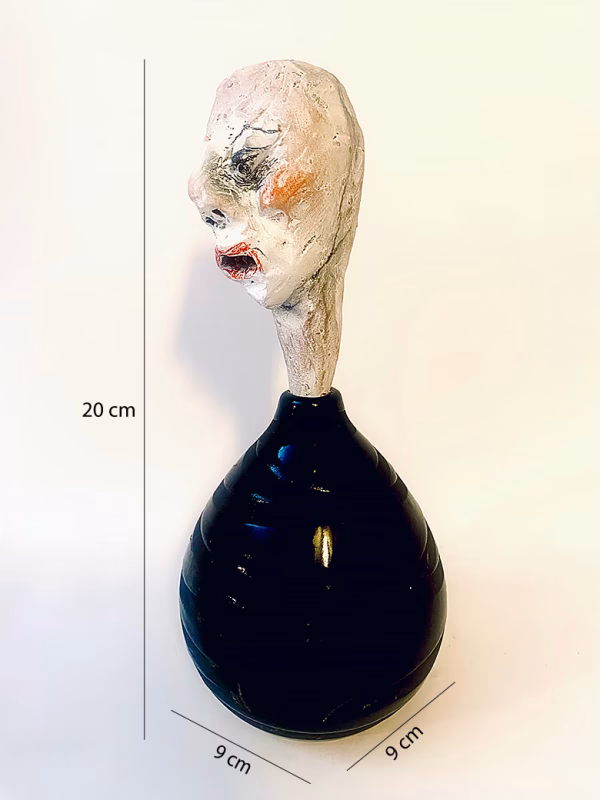 Small sculpture head emerging from ceramic pot