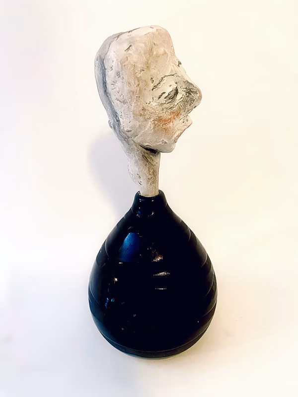 Small sculpture head emerging from ceramic pot