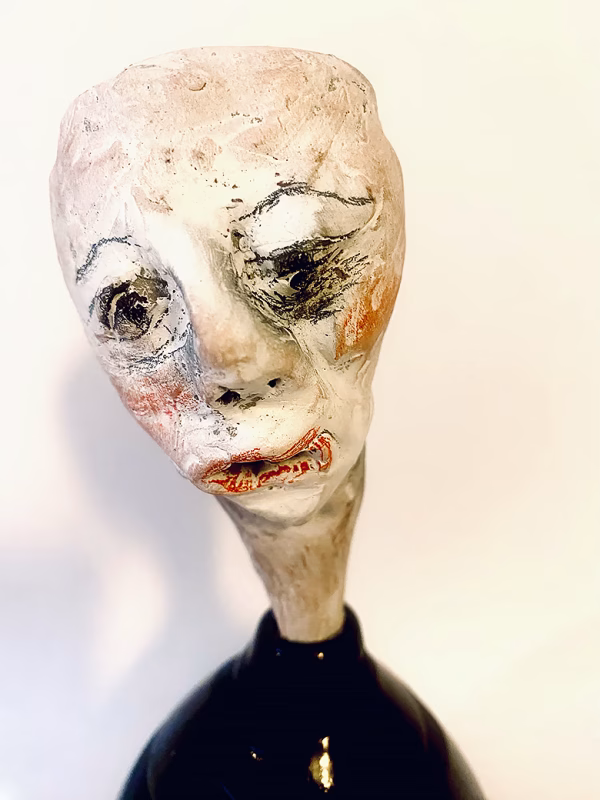 Small sculpture head emerging from ceramic pot