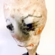 Small sculpture head emerging from ceramic pot (close-up)