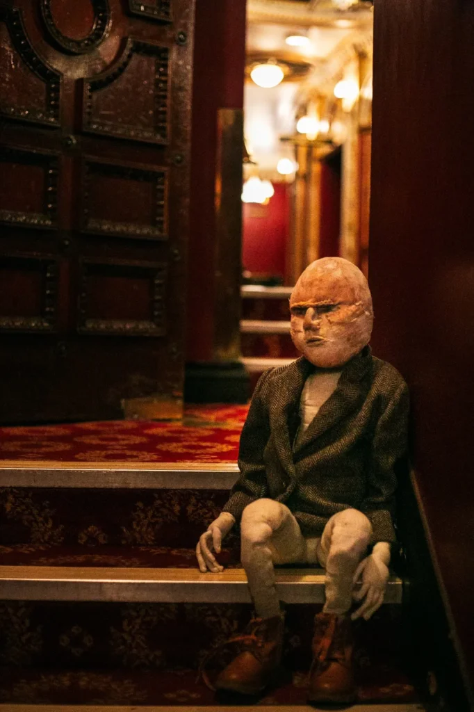 Soft textile sculpture sitting on steps in a theatre hallway
